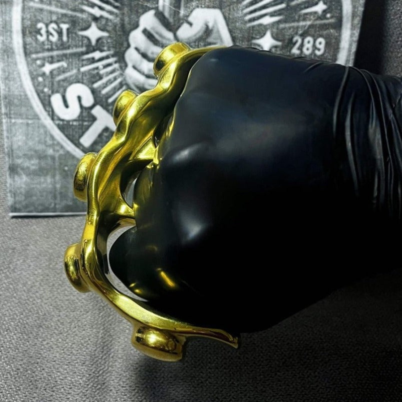Back view of brass knuckle duster showing ergonomic shape