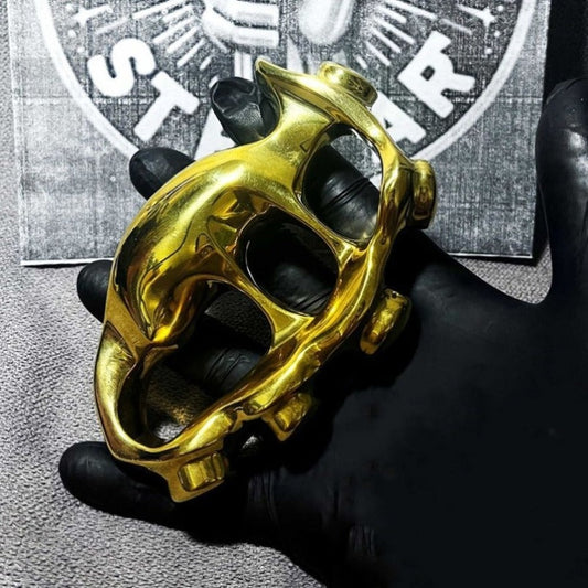 High quality solid brass knuckle duster held in black gloved hand