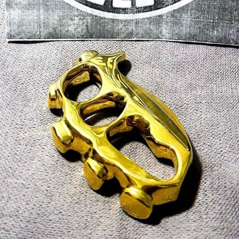 Close-up of brass knuckle duster finger holes and palm brace