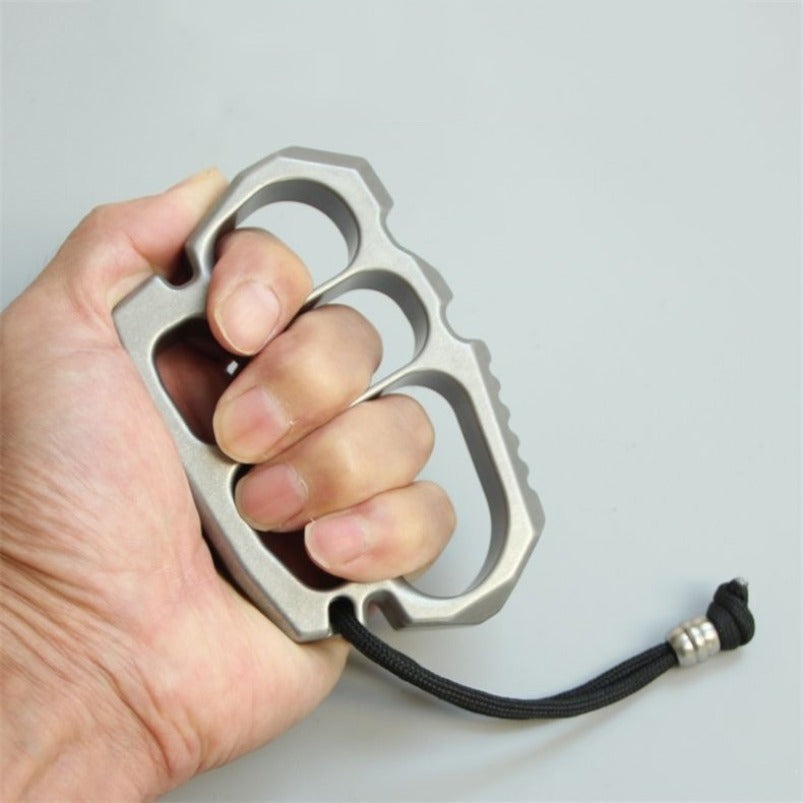 Top view of stainless steel knuckle duster showing four circular finger holes