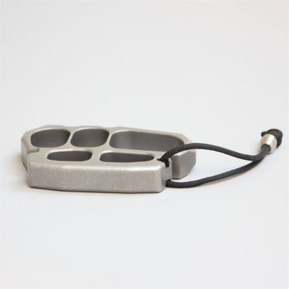 Stainless steel knuckle duster held in gloved hand for scale