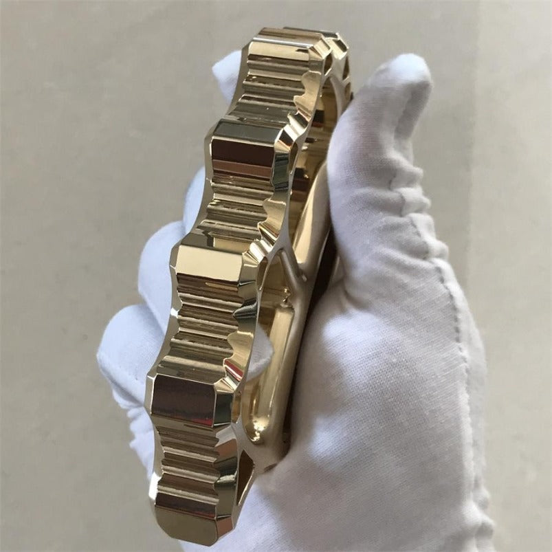 Angled view of brass knuckle duster decorative cutouts