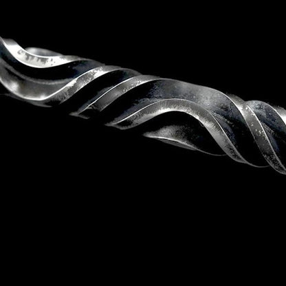 Forged metal hand stick lying on grey surface