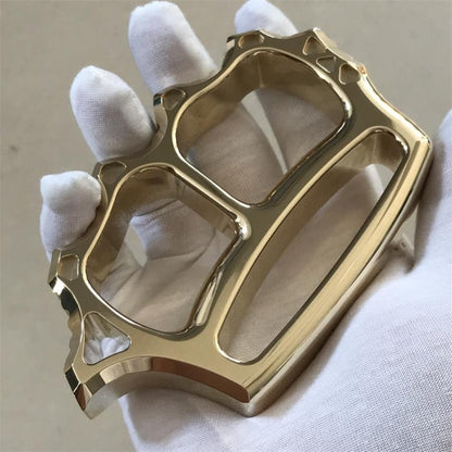 Two finger brass knuckle duster held in palm for scale