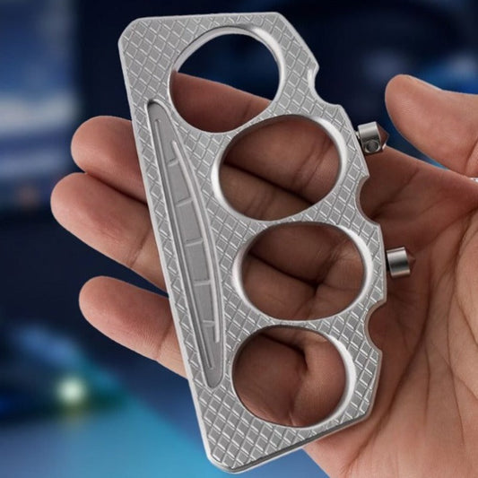 Zinc alloy cone tip knuckle duster held in a hand showing four finger holes and diamond-textured surface