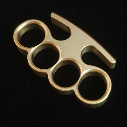 Solid brass knuckle duster front view showing four finger holes on black background