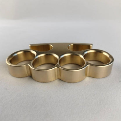 Top-down view of solid brass knuckle duster showing four circular finger holes