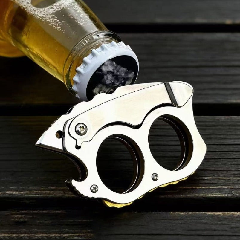 Mini knuckle knife being used as bottle opener on amber beer bottle