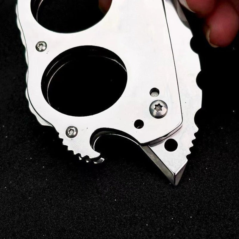 Close-up of mini knuckle knife blade and dual finger holes on black background