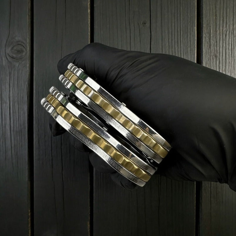 Stack of stainless mini knuckle knives showing side profile and thickness